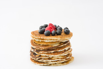 Pancakes with blueberries and raspberries isolated on white background
