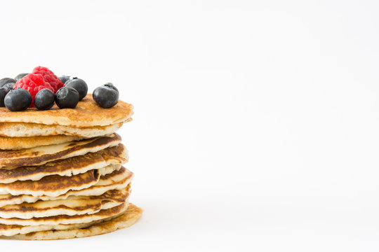 Pancakes with blueberries and raspberries isolated on white background
