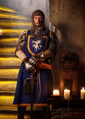 Medieval knight on guard in ancient castle interior.