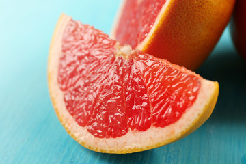 Juicy grapefruits on blue background, close up