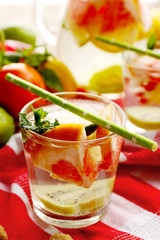 Refreshing cocktail with ice, mint, pomegranate seeds and slices of fruits on napkin
