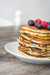 Sweet pancakes with blueberries and raspberries pon rustic wood

