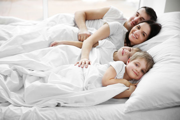 Obraz na płótnie Canvas Family awakening in bed, closeup