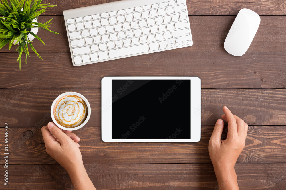Aufkleber hand using white tablet blank screen on table workspace