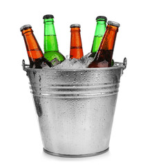 Beer bottles in ice bucket, isolated on white