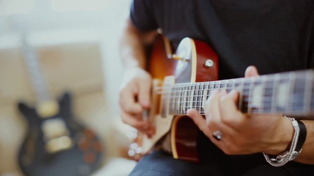 Man plays electric guitar at home