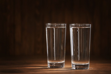 Glasses of water on wooden background