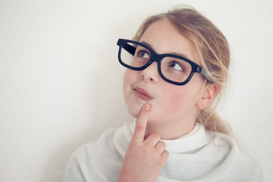 young girl with glasses thinking
