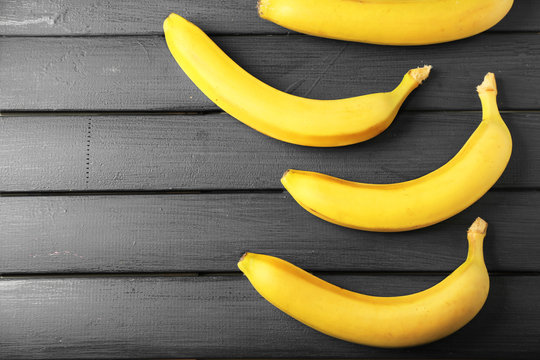 Ripe bananas on dark wooden background
