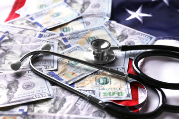 Stethoscope with dollar banknotes on background of USA flag