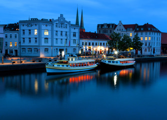 Fototapeta premium Lubeck at night with Untertrave river boardwalk