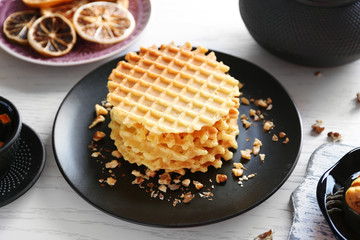 Fresh waffles with honey and dried oranges on wooden background