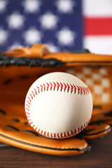 Baseball in glove in front of American state flag