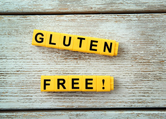 Phrase GLUTEN FREE made of yellow cubes on wooden background