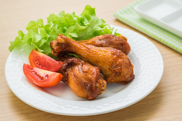 Grilled chicken legs and vegetables on plate