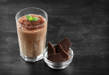 Fresh banana cocktail with chocolate on dark wooden background