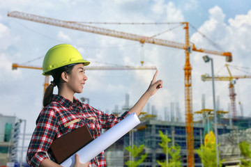 women asia engineer working and holding blueprints at constructi