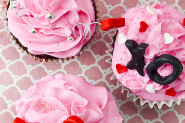 close-up cropped shot of three cupcakes with heart shape and xo symbol