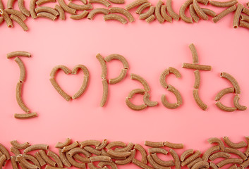 I love pasta inscription made with brown macaroni on pink background