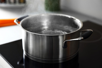 Boiling water in pan on electric stove in the kitchen