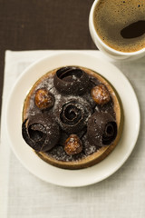 Chocolate tart with decoration and cup of coffee