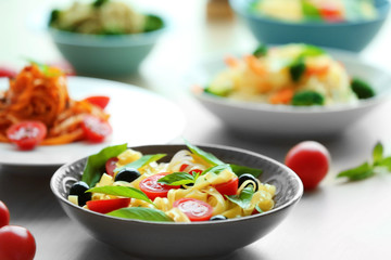 Different cold pasta salads in bowls on the table closeup