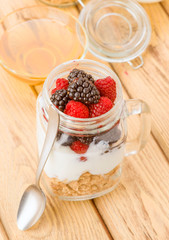 transparent jar with berries and yogurt cereals