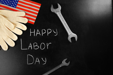 American holidays concept. Happy Labor Day with wrench and gloves on blackboard.