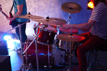 Drummer playing on drum set on stage.