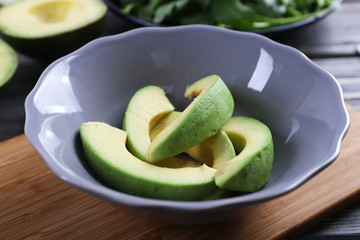 Plate with sliced avocado on cutting board, closeup