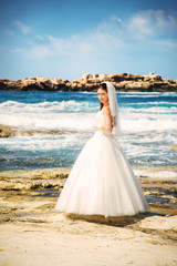 Fototapeta na wymiar outdoor portrait of young beautiful woman bride in wedding dress on beach