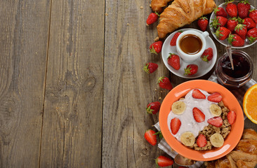Muesli with yogurt, croissant and fresh strawberries