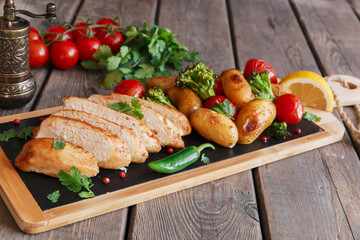 Chicken breast baked with tomato new potatoes and broccoli