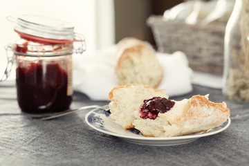 A fresh bread with strawberry marmalade for breakfast.