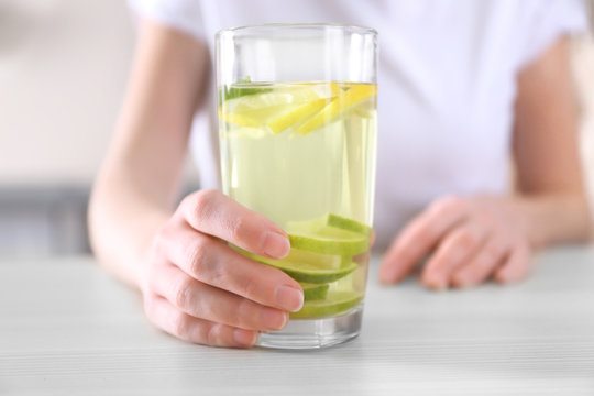 Female hand holding glass of lemonade closeup