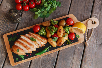 Chicken breast baked with tomato new potatoes and broccoli
