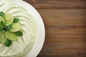 Delicious creamy lime cake on wooden table, top view