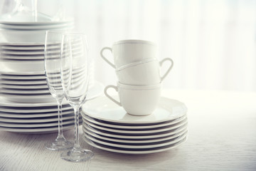 Set of new white dishes on wooden table, indoors