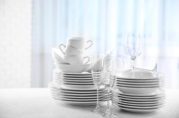 Set of new white dishes on wooden table, indoors