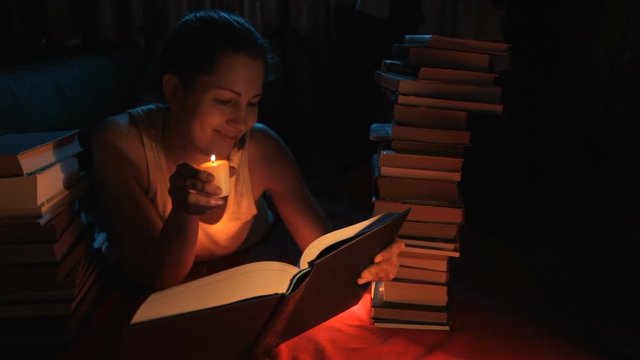 девушка читает книгу со свечей