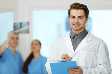 Fototapeta na wymiar A male doctor holding a clipboard in hospital