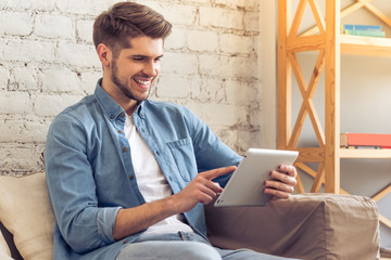 Young man with gadget at home
