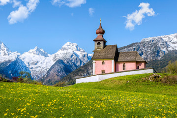 Alpine landscape with chapel and snow-capped mountains at Lofer,