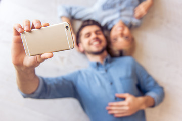 Beautiful couple at home with gadget