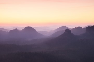 Tourist resort. Fantastic dreamy sunrise on the top of the rocky mountain with the view into misty valley