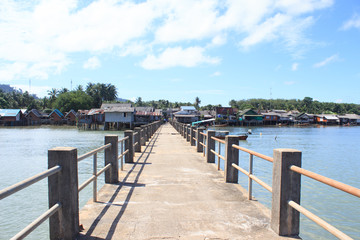 Fototapeta na wymiar old concrete bridge to dock fisherman village pier in tranquil sea destination ,Trang Thailand