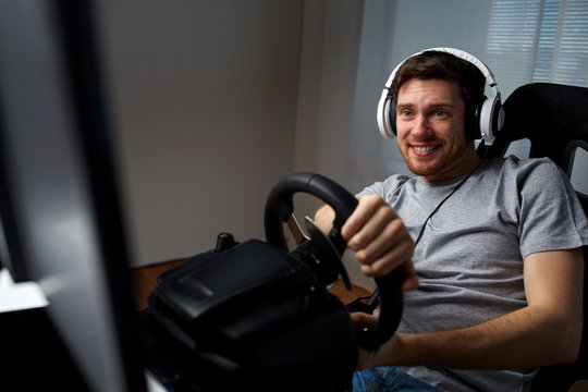 man playing car racing video game at home