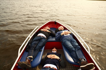 joy/ father and sons taking a nap while enjoying a boat ride together