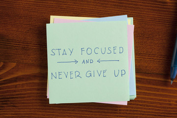 Stay focused and never give up written on note