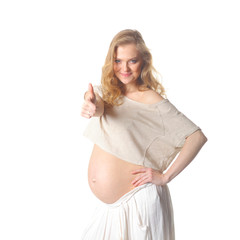 pregnant woman caressing her belly over white background. Positive pregnant woman shows thumb